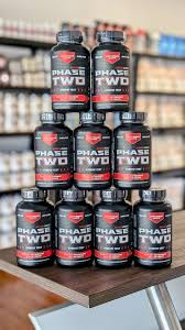 Optimus Jack Phase Two: mehrere Flaschen mit rotem „Phase Two“-Etikett, dicht gestapelt